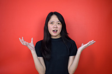 Portrait of Young beautiful asian woman using black T-shirt with red isolated background