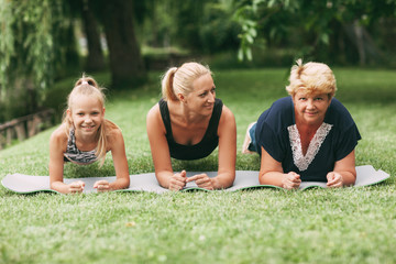 Grandmother, mom and child are doing fitness together in nature. Go in for sports. Healthy lifestyle