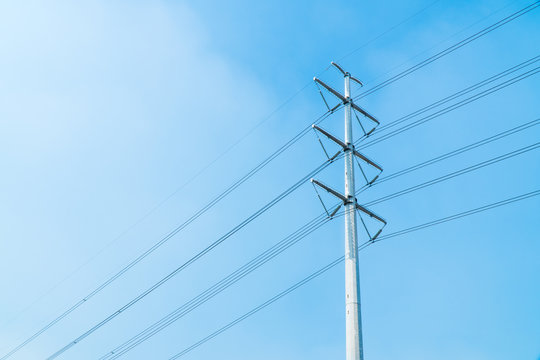Low angle view of new and clean single electricity pole with beautiful bright blue sky.