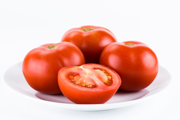 Close-up of fresh red tomatoes on a white dish.