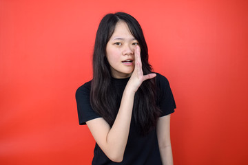 Portrait of Young beautiful asian woman using black T-shirt with red isolated background