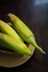 Ears of organic corn on a weaved basket. Harvested corn or Jagung.