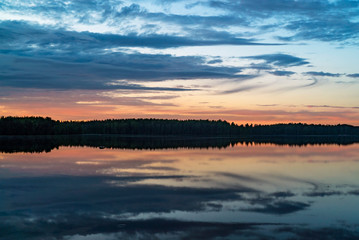 Fototapeta na wymiar Colorful sunset on a forest lake in summer.