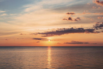 Obraz premium Beautiful orange sunset of the sea beach with rays of deep blue sky and sun
