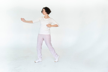 woman practicing qi qong at white studio traditional chinese gymnastics	