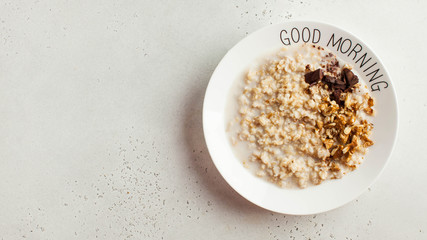 Banner oatmeal porridge with chocolate and nuts on a plate that says good morning. Healthy food, Breakfast. Copy space.