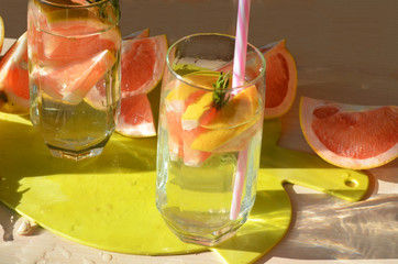 Girl cooking healthy detox smoothie with fresh fruits and green rosemary grapefruit water. Lifestyle detox concept