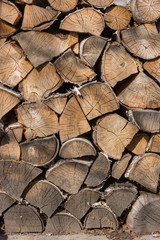 Birch firewood. Front image of firewood saw cuts. Firewood is dried and ready to kindle a fireplace. Cracked wood, texture is clearly visible. Vertical photo, daylight