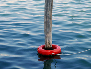 pali di legno in mare con boe, galleggianti e riflessi