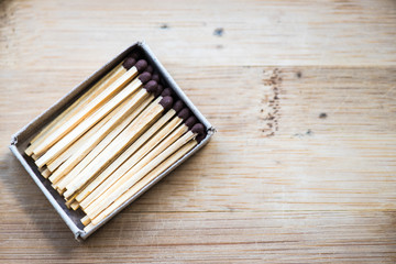 Box with matches on a wooden background