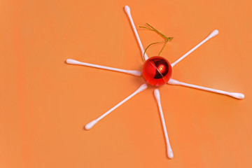 Christmas tree toy and snowflake made of cotton swabs on an orange background close up