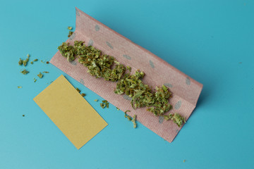 Joint paper for cannabis roll on blue background top view, marijuana smoking accessory