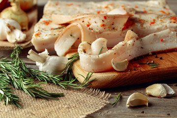 Lard with spices and herbs on a old wooden table.
