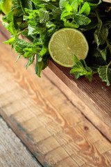 Fresh green mint and lime on a old wooden table.