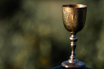 Holy Grail. Elegant, glod, vintage cup on blurry background.