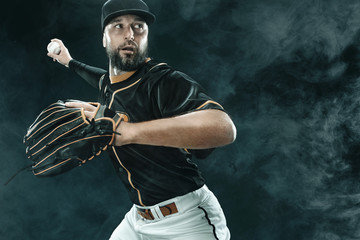 Baseball player with ball. Ballplayer on black background.