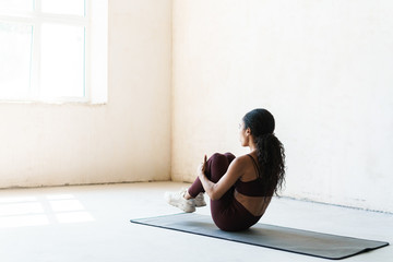 Photo of african american woman doing exercise on mat while working out