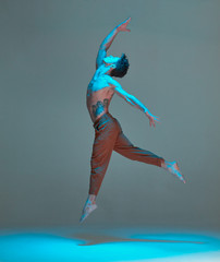 Cool young guy dancing and floating in the air in a jump in neon light. Dance school poster. Dance...