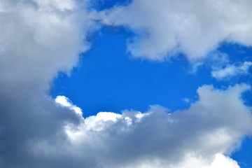 blue sky with white clouds on which the heart is outlined