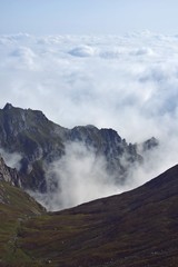 fluffy white clouds among the mountain ridges. mist at high altitude