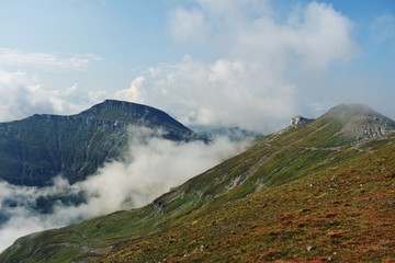 Obraz na płótnie Canvas fluffy white clouds among the mountain ridges. mist at high altitude