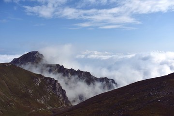 fluffy white clouds among the mountain ridges. mist at high altitude