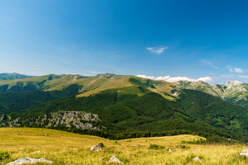 Fototapeta na wymiar Godeanu and Retazatul Mic mountains from meadow bellow Osleva hill in Valcan mountains in Romania