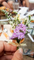
A small bouquet of flowers in a woman's hand