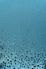 Macro raindrops vapor on window glass. Rain drops on window glasses surface. Through the window view. Drops of rain on glass. Water pattern texture