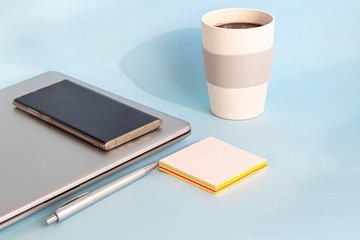 Quarantine, online training, work from home. Laptop, phone and pen, stickers and coffee in a...
