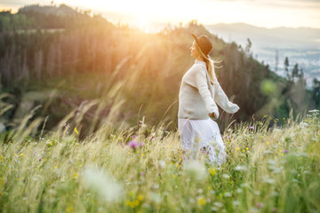 Happy woman enjoying sunset stay on the green grass 