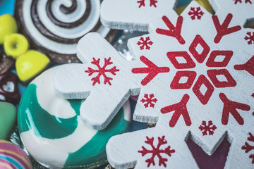 Snowflake toy on candy background top view close up