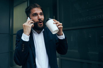 Business man in a suit holding a phone cup of drink lifestyle