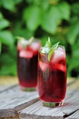 
glass with red cocktail on wooden table