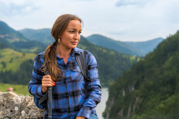 Naklejka premium Portrait of Beautiful woman with backpack and blue shirt. Enjoying nature that surround her.