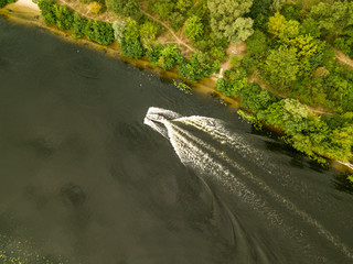 Aerial drone view. The motor boat sails along the river.