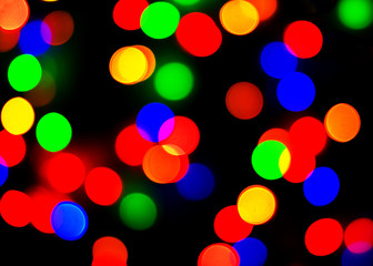 Defocused Lights Background. Multicolored defocused lights on black background. Copy space.