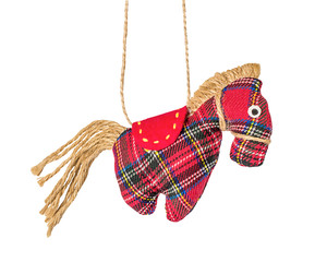 Christmas decoration on a white background isolated. A toy cloth horse. Side view. Close up. Zero waste Christmas. 