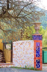 mosaïque portail fer forgé et arbre sans feuille en automne en région de provence