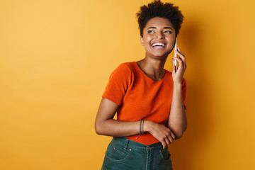 Image of african american woman laughing and talking on mobile phone