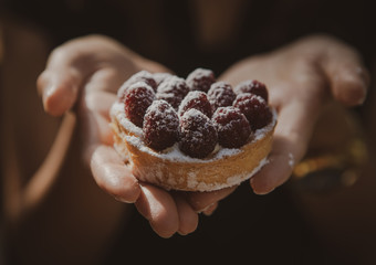 fresh cake with berries in hands