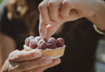 fresh cake with berries in hands