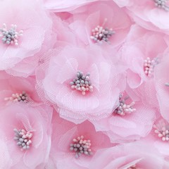 Artificial handmade flowers made out of beautiful organza and tulle fabric texture in soft pink color