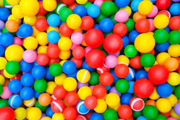 Fototapeta na wymiar A background of bright, colored plastic balls. Top view, close-up. Backing for your lettering. The balls are red, blue, yellow and green.