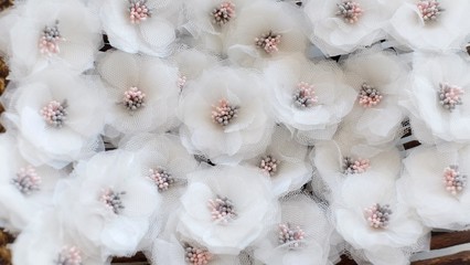 Artificial handmade flowers made out of beautiful organza and tulle fabric texture in broken white...