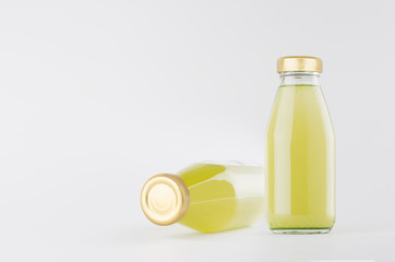Green vegetables juices in glass bottles with gold empty cap for label mock up on white background...