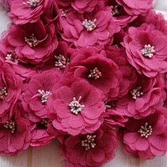 Artificial handmade flowers made out of beautiful fabric texture in pastel magenta color
