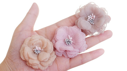 Artificial handmade flowers made out of beautiful fabric texture in pastel soft brown, beige, and pink colors