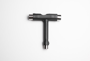 Skate tool, used for adjusting wheels, trucks, and other parts on skateboards and longboards.  Close up isolated on white surface.