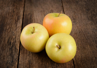 Ripe yellow apple fruit on wood background